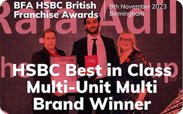 Three people stand on stage holding an award certificate at the BFA HSBC British Franchise Awards. Text reads: HSBC Best in Class Multi-Unit Multi Brand Winner. 9th November 2023, Birmingham.